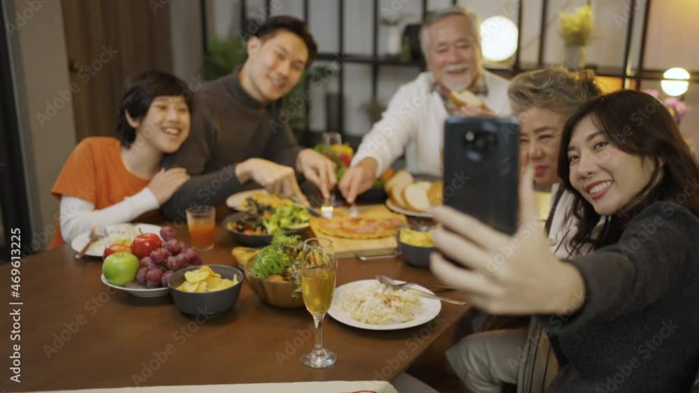 Asian family having taking selfie before dinner at dining table at home Asian family having taking selfie before dinner at dining table at home