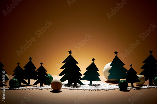 Pine tree with snow and christmas twinkle ornament in shiny brown background   photography holiday content   front view