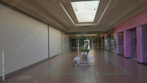 This panning video shows an abandoned and eerie empty shopping mall interior. photo