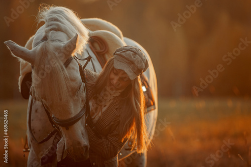 Beautiful young woman in English hunter wear style with Knabstrupper horse and Irish setter at autumn park