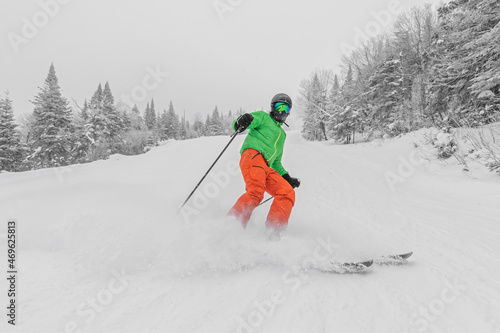 Skiing. Man on ski in Alpine ski concept - Skier skiing downhill doing hockey stop at mountain snow covered ski trail slopes in winter on perfect powder snow day while enjoying nature landscape