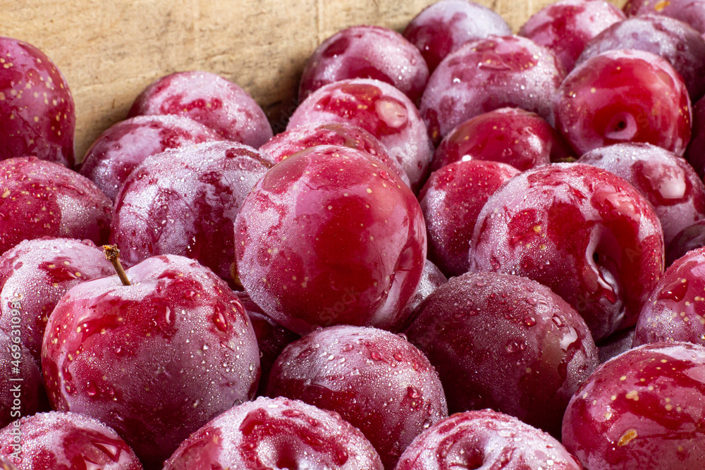 Ripe large plums in a wooden box close-up Ripe large plums in a wooden box close-up