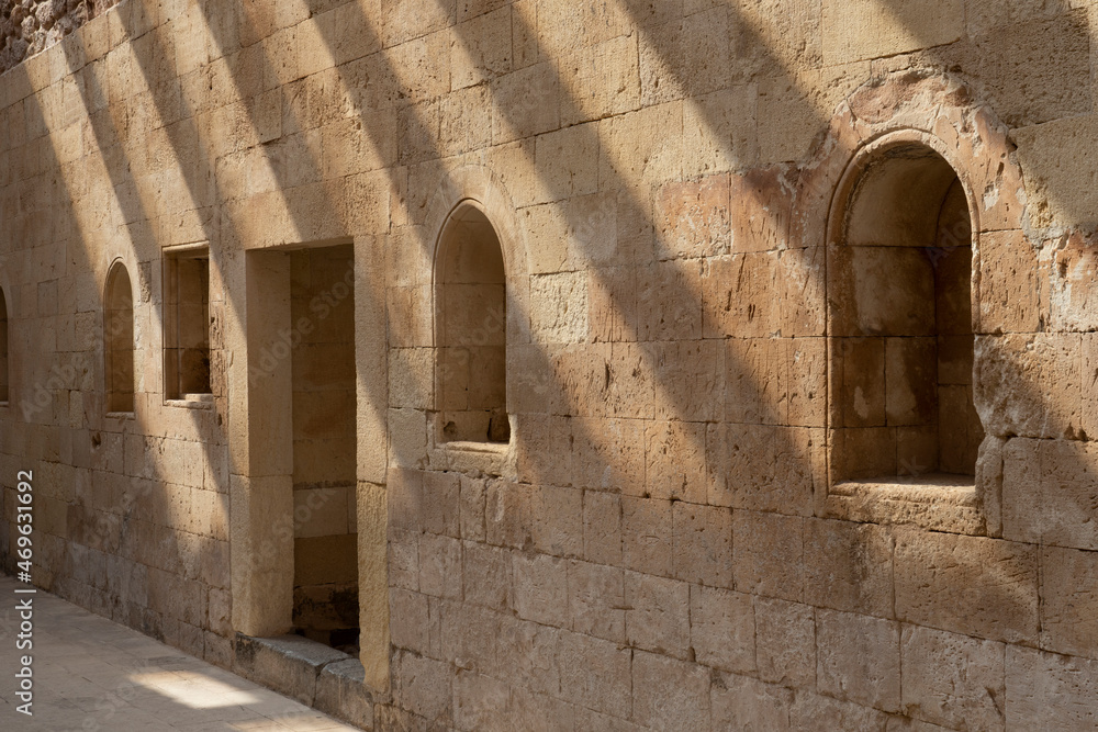 Fototapeta premium Wall of an old palace with window openings and beautiful shadows