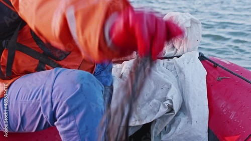 Hands of fihserman pulling fishing net out of river water. Man hobby and activity photo