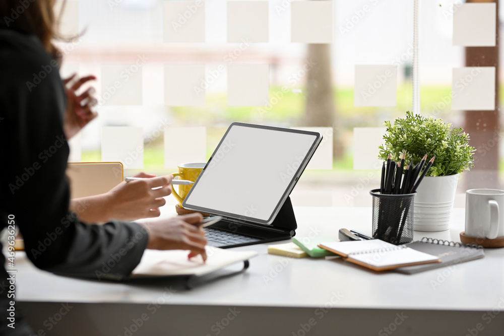 Female employee using digital tablet computer in office room. Female employee using digital tablet computer in office room.