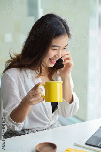 Businesswoman drink coffee while having a good talk on the phone
