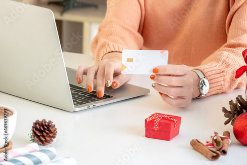 woman hand using laptop computer and holding credit card for christmas online shopping
