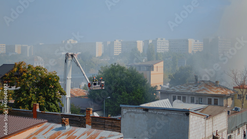 Photos Men from fire department using firetruck to help firefighters on building