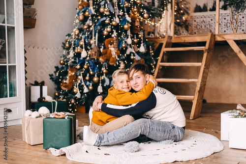 two boys playing in a room with christmas tree