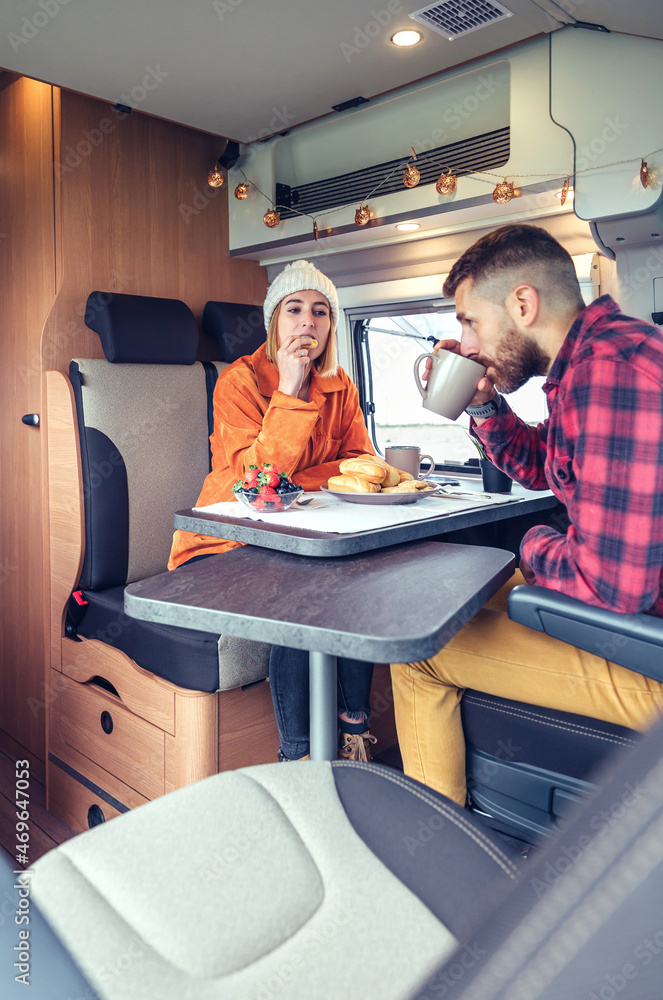 Friends having breakfast in a camper van in the morning Friends having breakfast in a camper van in the morning