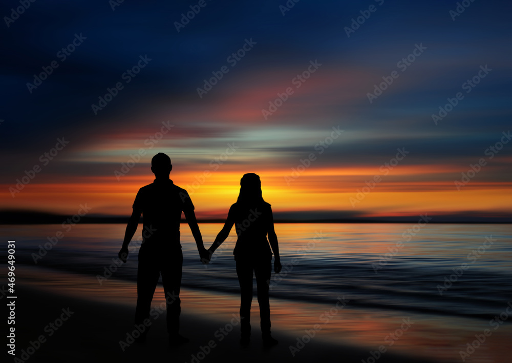 Sunset silhouette of a couple holding hands on the beach