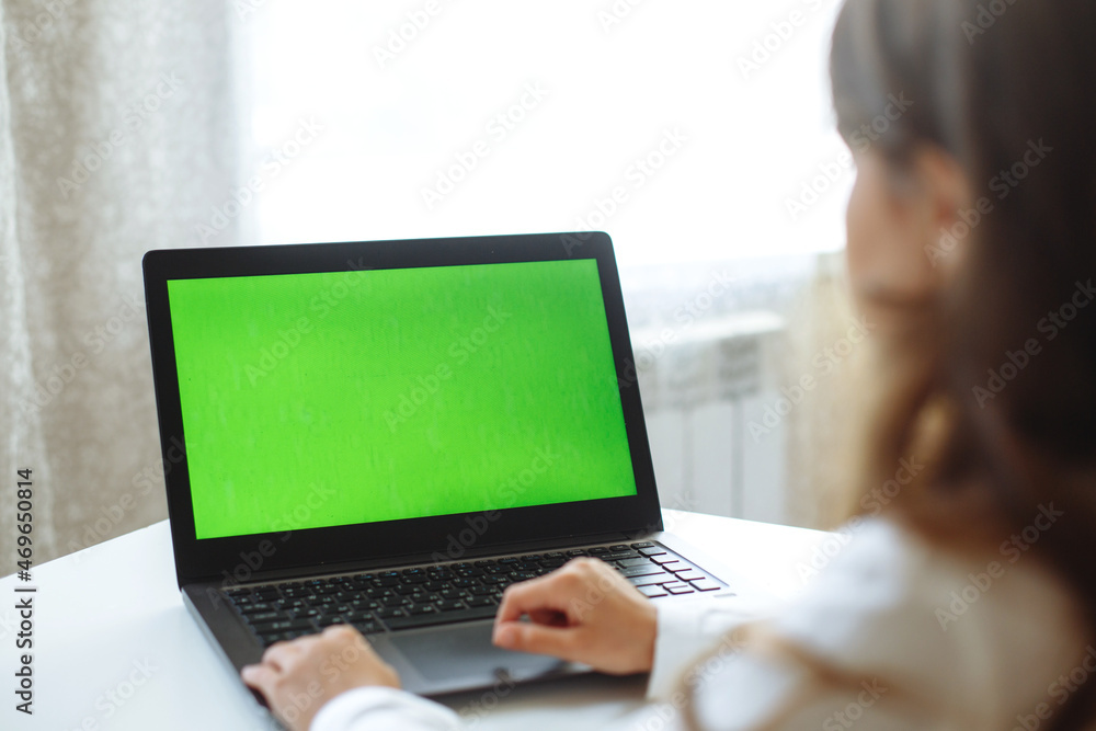 A girl behind the laptop with a green screen A girl behind the laptop with a green screen