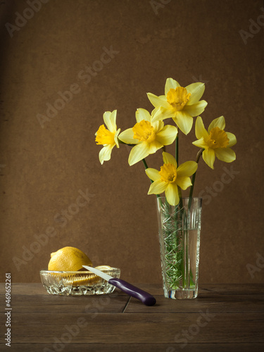 daffodils in a crystal vase. Sliced lemon in a crystal saucer.