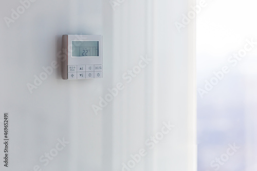 The air conditioning and heating control panel for the apartment and office is located on a white wall photo