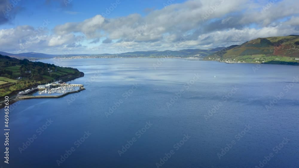 Carlingford Lough, Louth, Ireland, October 2021. Drone gradually ascends while facing west towards Carlingford Marina with Warrenpoint in Northern Ireland. Carlingford Lough, Louth, Ireland, October 2021. Drone gradually ascends while facing west towards Carlingford Marina with Warrenpoint in Northern Ireland.