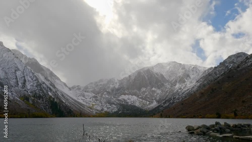 Snowy Sherwin Range mountains at Convict Lake with stormy clouds starting to snow, in Mono, California - Static handheld photo