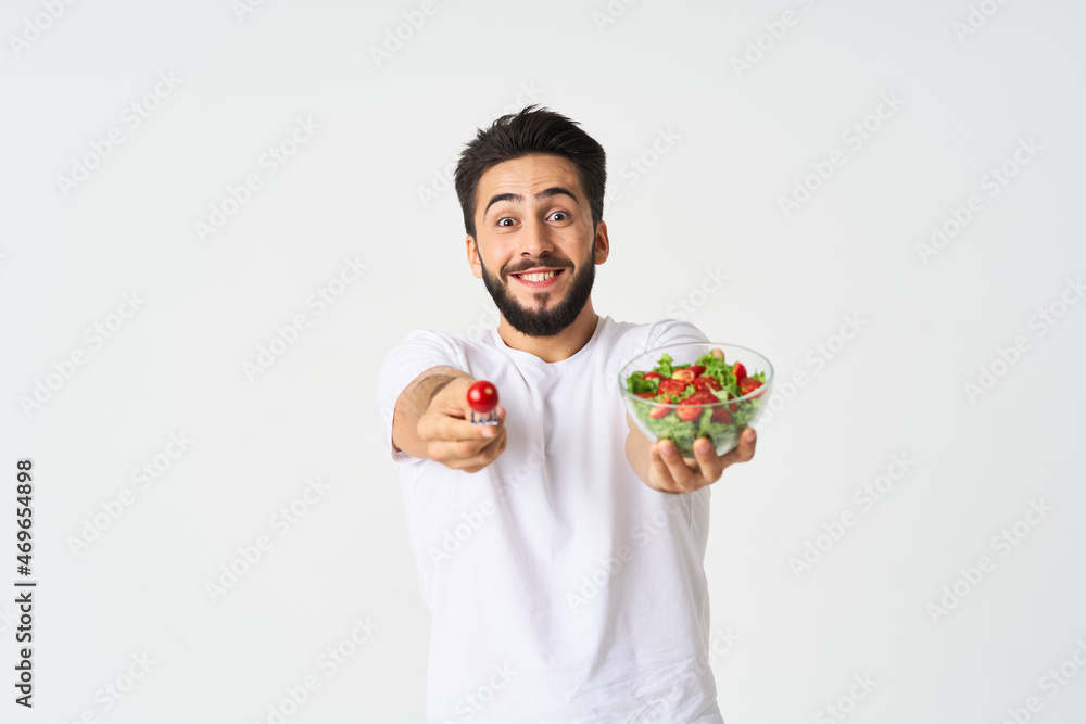 cheerful man in a white t-shirt a plate with salad vegetables diet cheerful man in a white t-shirt a plate with salad vegetables diet