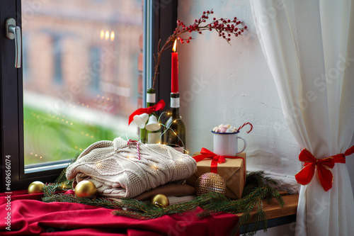 Obraz na plátně winter holidays concept - close up of warm wool braided sweater, candy cane, ele