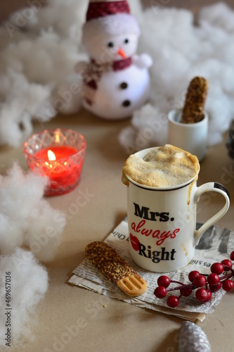 A photograph of a coffee drink, with a winter decor of snow, snowman, red wax and biscuits, food photography