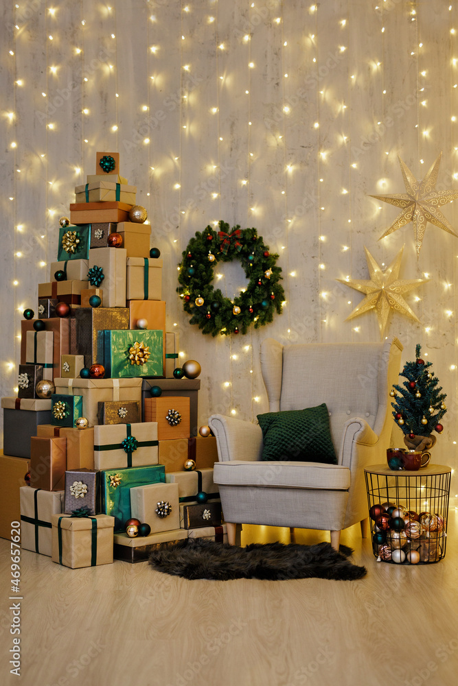 vintage armchair, wreath and Christmas gift boxes laid out in the shape of a Christmas tree over led lights