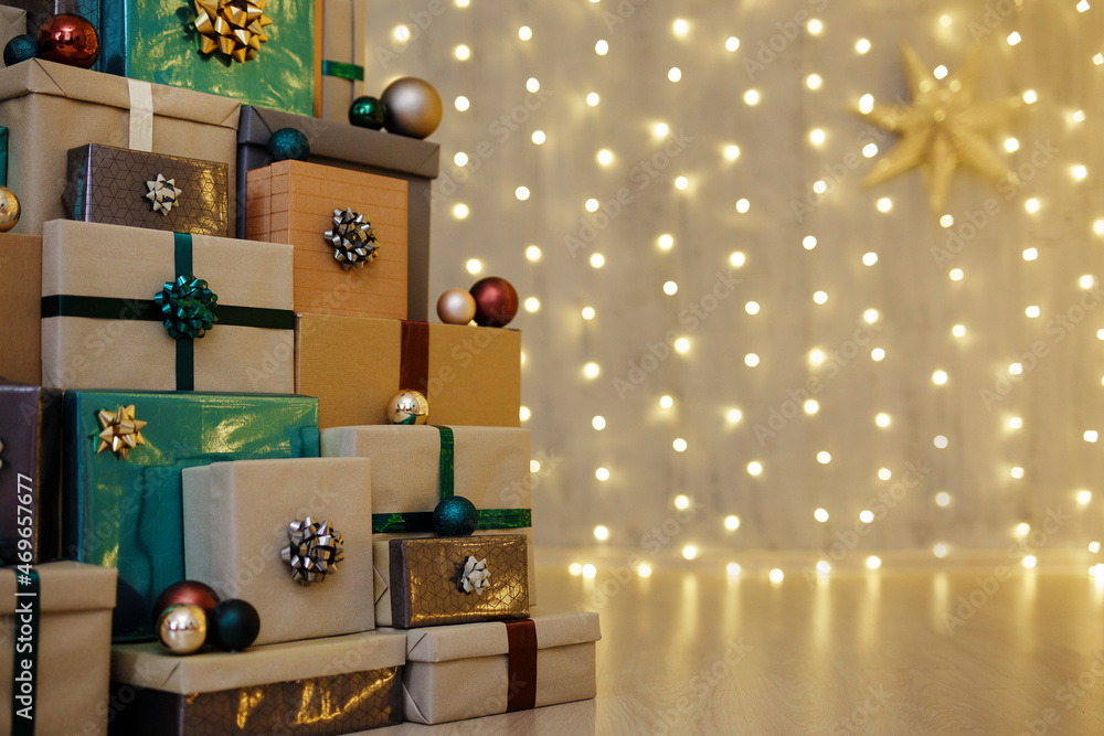 pile of Christmas gift boxes on wooden floor over led lights
