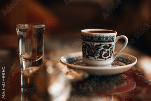 A cup of traditional black strong Turkish coffee, sweets delight and a small glass of water. Traditional drinks, coffee concepts.