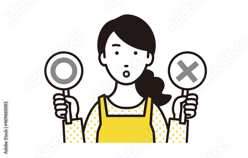 マルとバツの札を持つエプロン女性