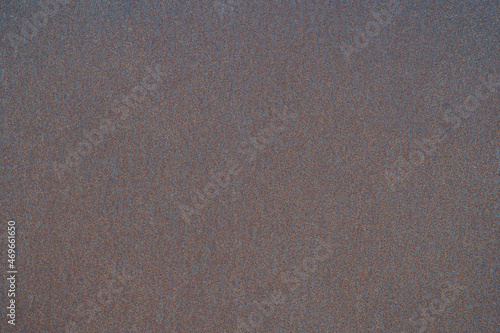 Rusty dark metal sheet with uniform corrosion in uniform lighting. Background
