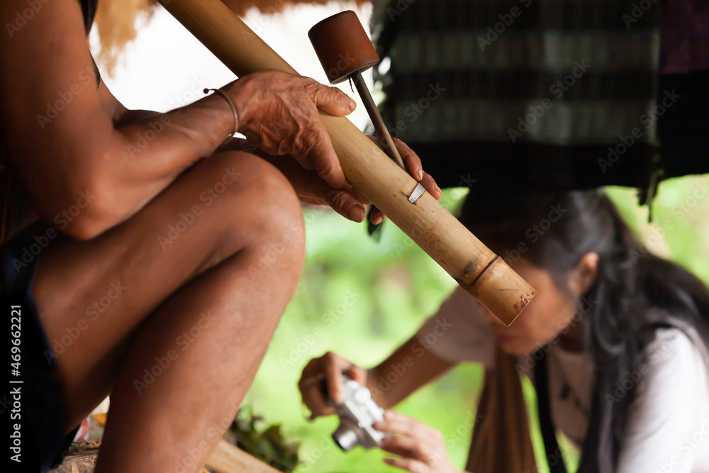 Lavae tribe man smoking tobacco while a tourist visiting village.