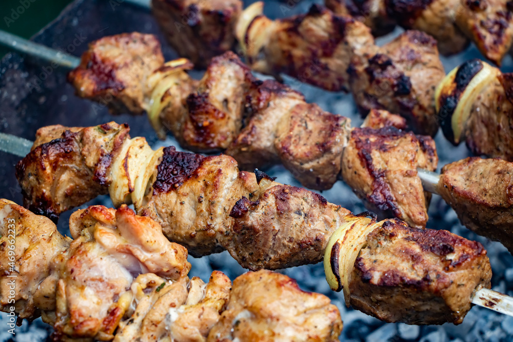 Preparing pork shashlik on the charcoal mangal. Pork grill, Pork shashlik. Marinated shashlik preparing on a barbecue grill over charcoal Preparing pork shashlik on the charcoal mangal. Pork grill, Pork shashlik. Marinated shashlik preparing on a barbecue grill over charcoal