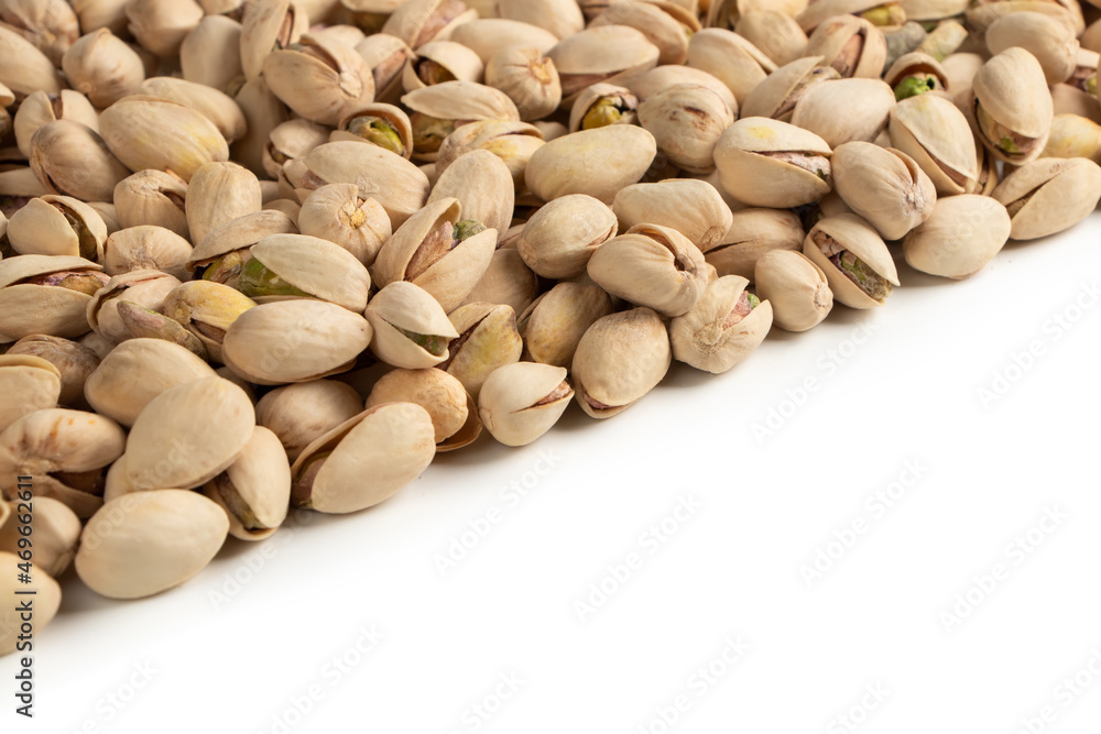 Roasted and salted pistachios in shell on white background copy space