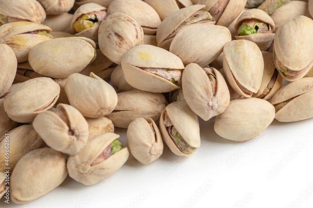 Roasted and salted pistachios in shell on white background copy space Roasted and salted pistachios in shell on white background copy space