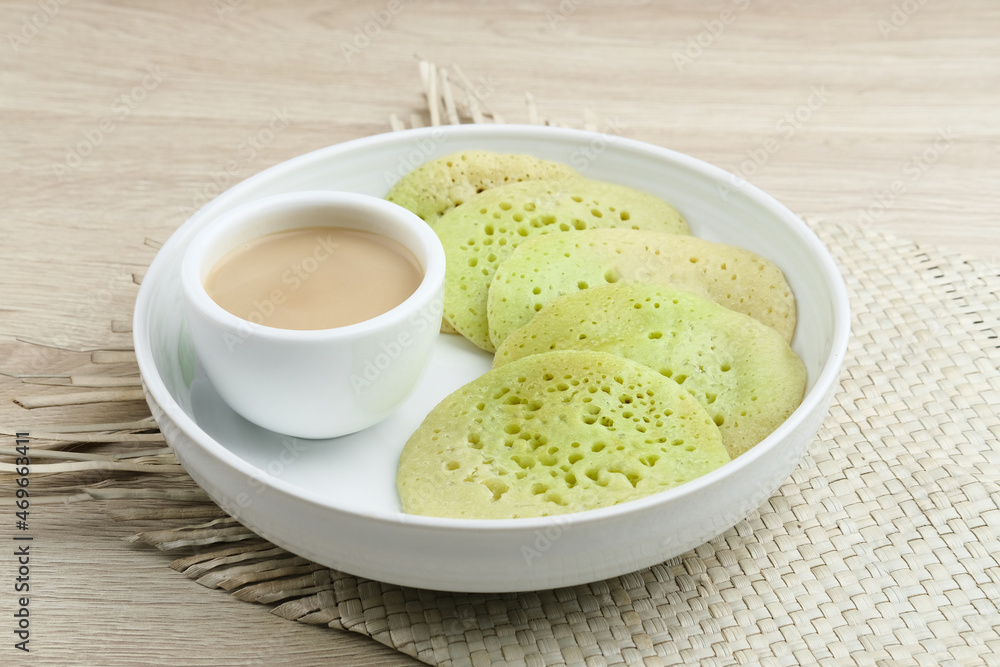 Serabi or Surabi, Indonesian pancake made of flour, rice flour and coconut milk. Served with palm sugar sauce. Sweet and savory. Selective focus image.
Serabi or Surabi, Indonesian pancake made of flour, rice flour and coconut milk. Served with palm sugar sauce. Sweet and savory. Selective focus image.