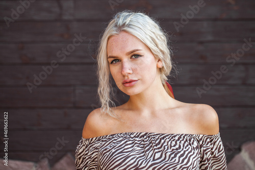 Young blonde woman posing on a wooden wall background © Andrey_Arkusha