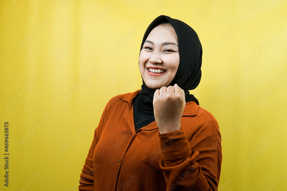 Beautiful young asian muslim woman with hands clenched, sign of success, punching, fighting, not afraid, victory, smiling confident, enthusiastic and cheerful, isolated Beautiful young asian muslim woman with hands clenched, sign of success, punching, fighting, not afraid, victory, smiling confident, enthusiastic and cheerful, isolated