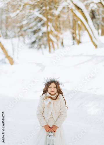 Amazing little girl holding Christmas lantern outdoors on beautiful winter sunny day