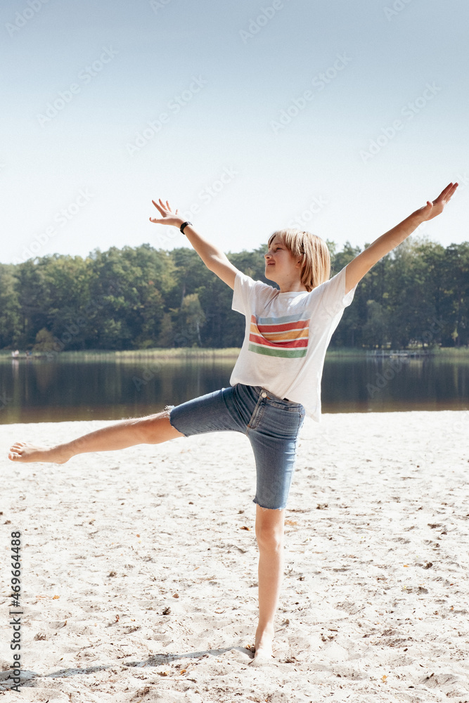 Obraz premium Beautiful teen girl rests on a sand beach