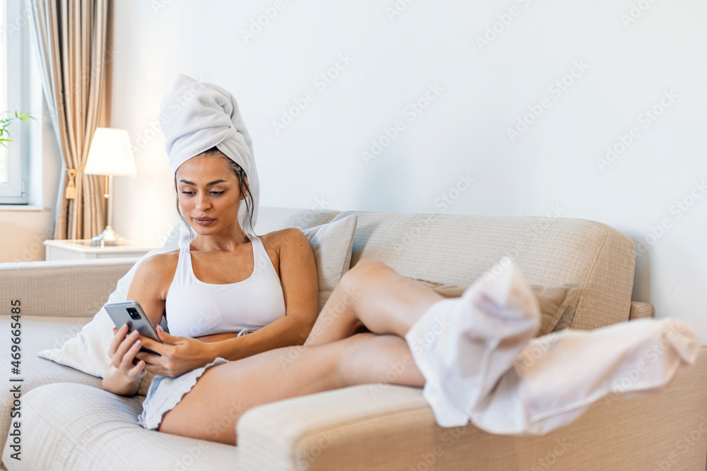 Moisturizing foot mask, for dry heels of the feet. Woman wearing disposable moisturizing socks for the legs. After a shower, a girl wrapped in a towel uses moisturizing foot mask. Cosmetic trends Moisturizing foot mask, for dry heels of the feet. Woman wearing disposable moisturizing socks for the legs. After a shower, a girl wrapped in a towel uses moisturizing foot mask. Cosmetic trends