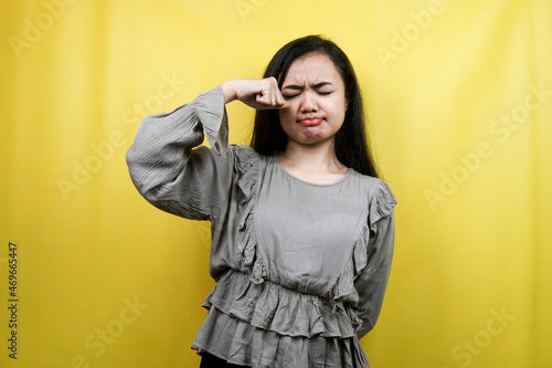 Beautiful young woman crying, wiping tears, sad, isolated