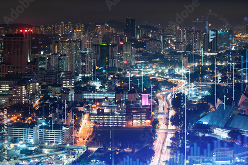 Stock market graph hologram  night panorama city view of Kuala Lumpur. KL is popular location to gain financial education in Malaysia  Asia. The concept of international research. Double exposure.