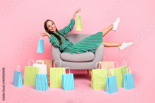 Full size profile side photo of young cheerful girl sit lounger enjoy shopping boutigue wardrobe isolated over pastel color background