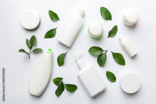 Organic cosmetic products with green leaves on white background. Flat lay