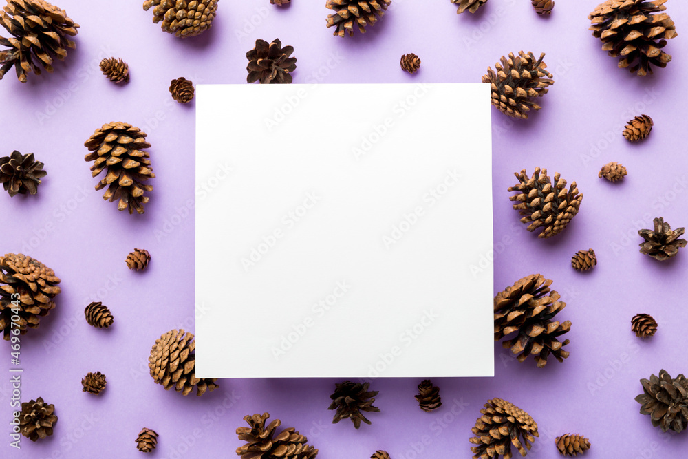 Creative frame made of Christmas pine cones with square Paper blank. Xmas and New Year theme. Flat lay, top view copy space