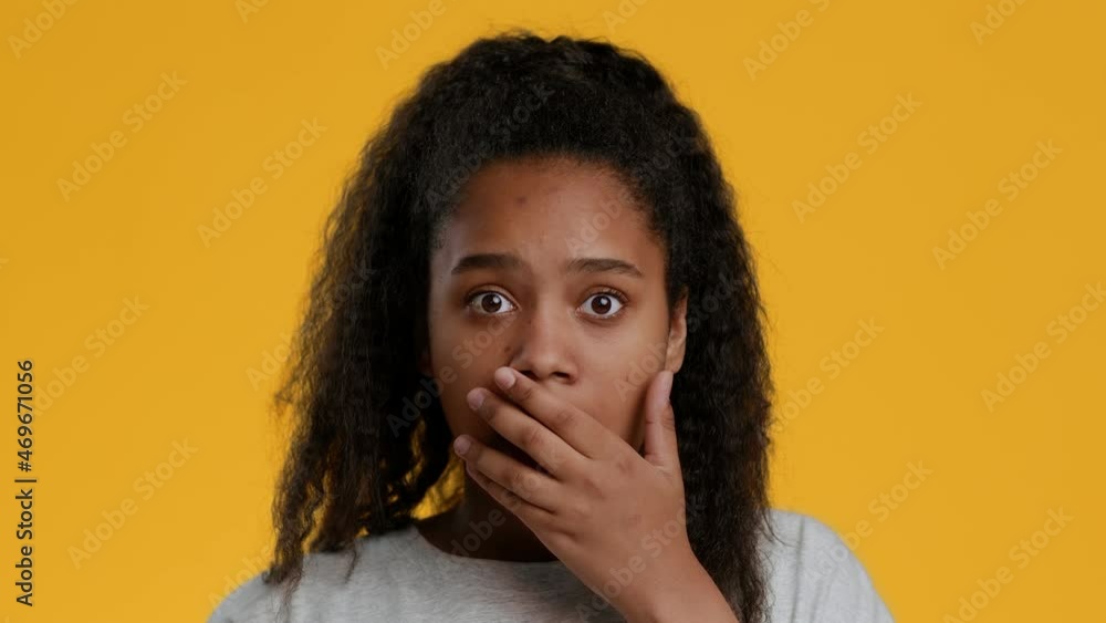 Shocked Black Teen Girl Covering Mouth With Hand, Yellow Background Shocked Black Teen Girl Covering Mouth With Hand, Yellow Background