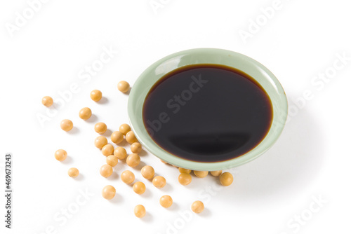 bowl of soy sauce and soybean on white background