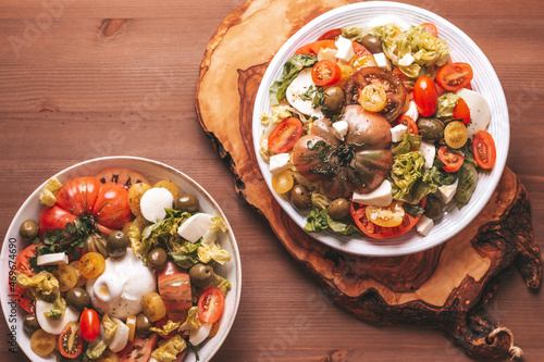 Billede på lærred Mediterranean style tomato heirloom salad in white plate on wooden table