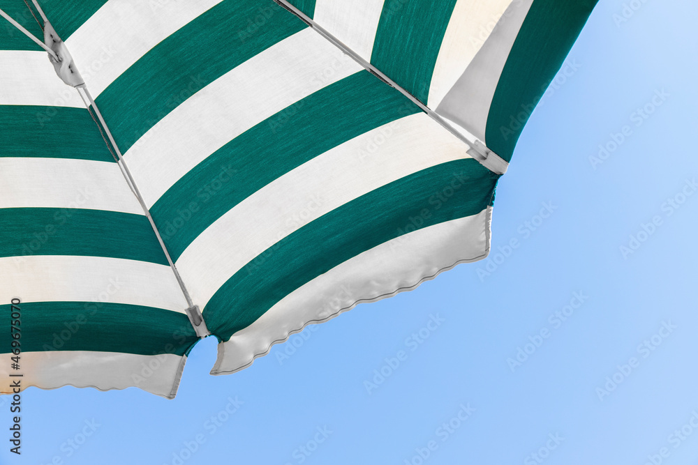 Part of the beach umbrella with white and green stripes in the middle ...