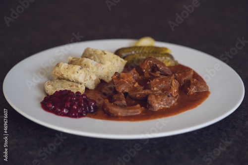 ready to eat - delicious goulash of chamois meat with napkin dumplings, pickles and cranberries