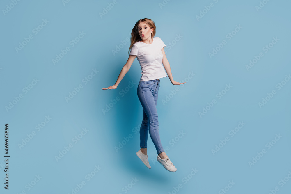 Photo of excited nice cheerful blonde lady careless jump wear casual clothes on blue color background Photo of excited nice cheerful blonde lady careless jump wear casual clothes on blue color background