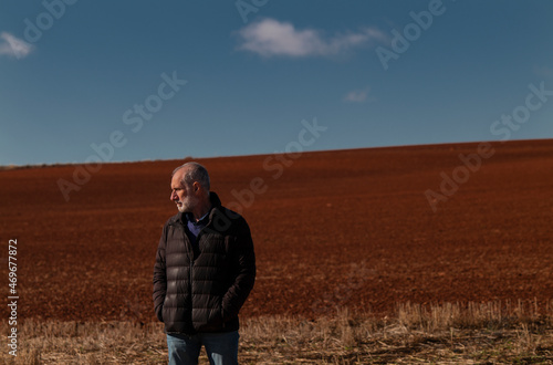 Portrait of adult man in winter cloth on field against blue sky. Shot in Castilla y Leon, Spain © WeeKwong